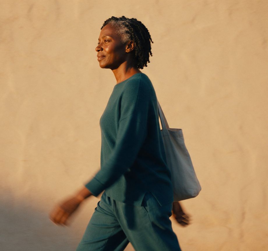 A woman walking past a warm wall